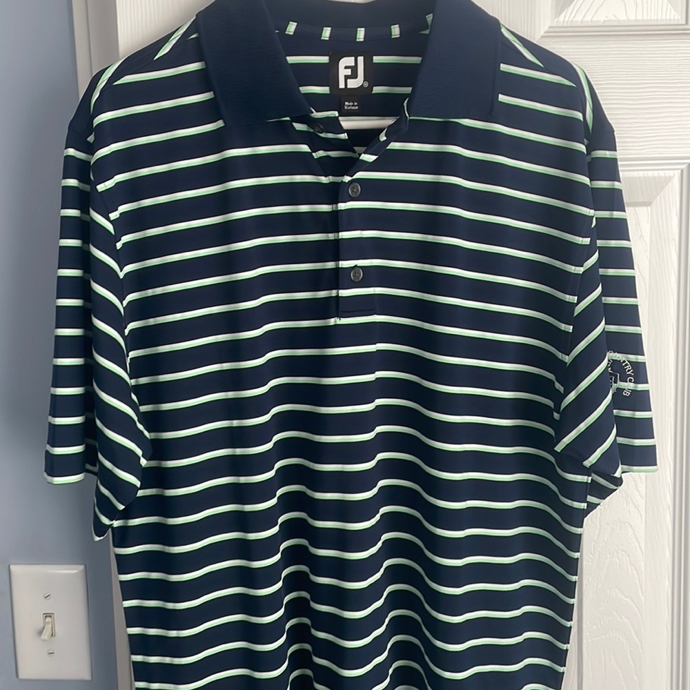 Footjoy golf shirt with stock wood country club logo on sleeve.